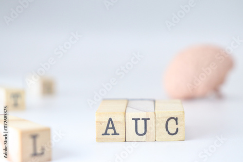 Acronym for automatic learning AUC. Area Under the Curve written on wooden cubes isolated with a brain on a white background with copy space.