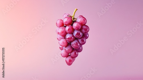 A minimalist shot of a single grape cluster suspended in the air against a soft gradient background.