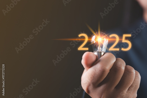 Businessman holding a light bulb symbolizing innovative management ideas for 2025, focusing on resource efficiency, sustainable planning, and creative strategies to shape the future of enterprises