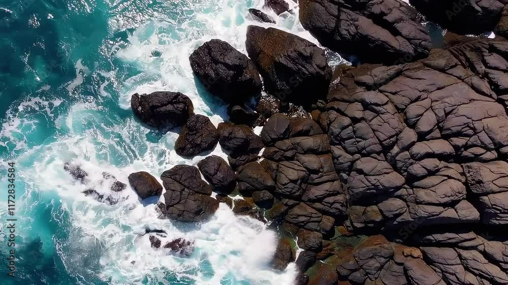 Waves Crash Against Rocky Shoreline at Coastal Location During Bright Day Waves Crash Against Rocky Shoreline at Coastal Location During Bright Day