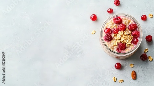 Jar of overnight oats with layers of berries and nuts, light gray background