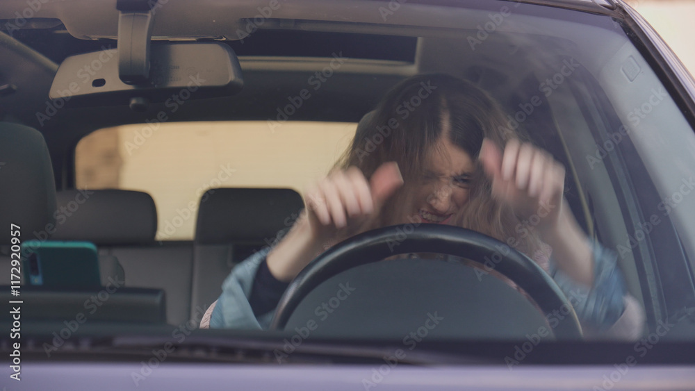 Frustrated young woman hitting steering wheel while driving
