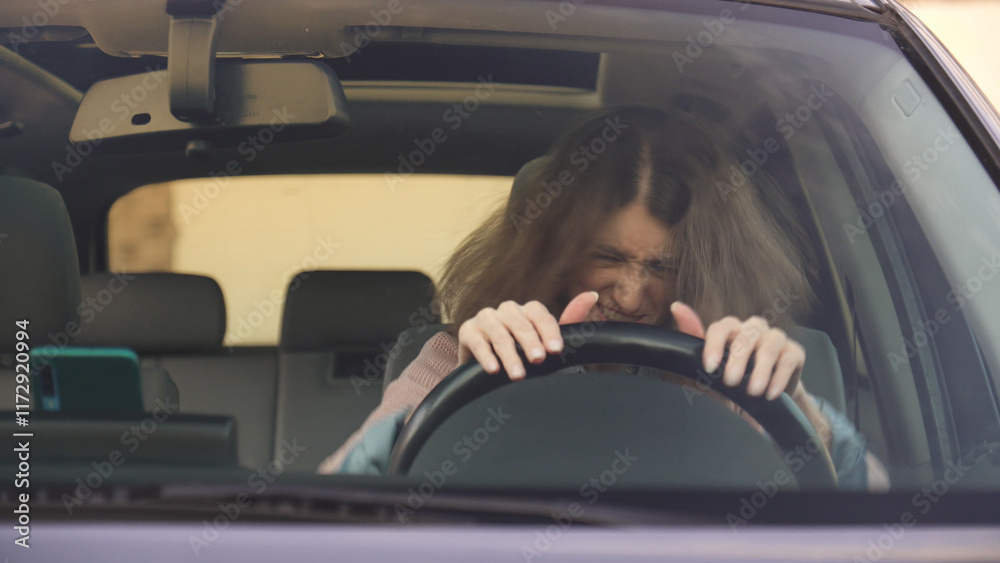 Stressed young woman banging steering wheel in traffic jam