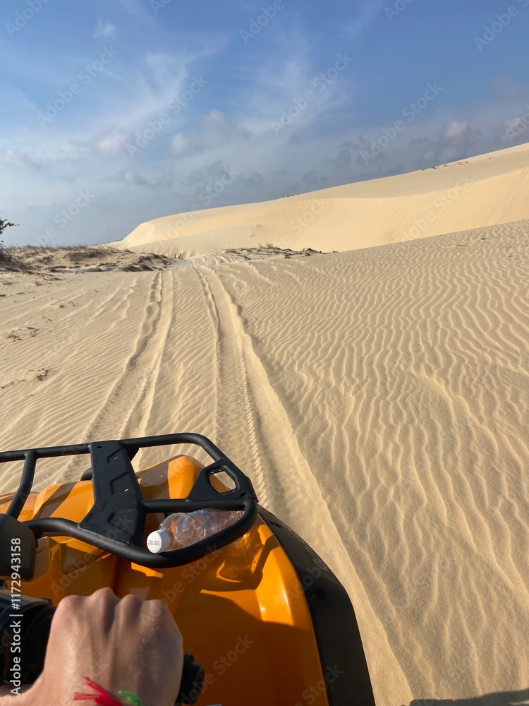 A thrilling perspective from a quad bike riding across the golden sand dunes of Mui Ne, Vietnam A thrilling perspective from a quad bike riding across the golden sand dunes of Mui Ne, Vietnam