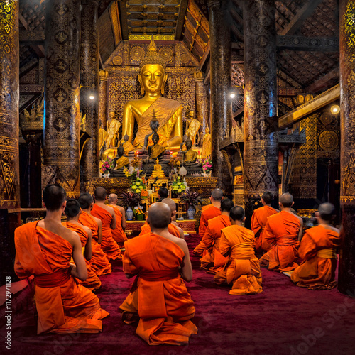 Monk Praying in Wat Xieng Thong temple, Luang Prabang, Laos. Buddhism culture and religion	 photo