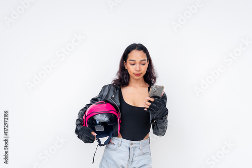 Motorcycle rider checking her phone while holding a helmet, isolated on white photo