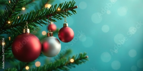 Multicolored ornaments hang from a teal tree branch, Christmas tree, greenery, ornaments