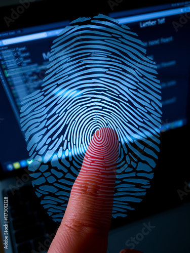 Finger print over computer on the desktop background. Top view. Double exposure. Concept of securitization. photo