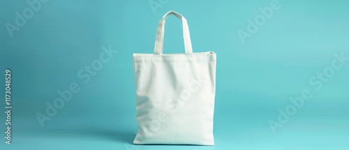 White fabric shopper with long handles on a blue background. Suitable for packaging design, eco-goods advertising and brand promotion. photo