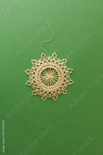 Snowflakes are made of straw on a green background. Christmas decor. Straw star. Top view. Straw weaving. Lutsk, Ukraine