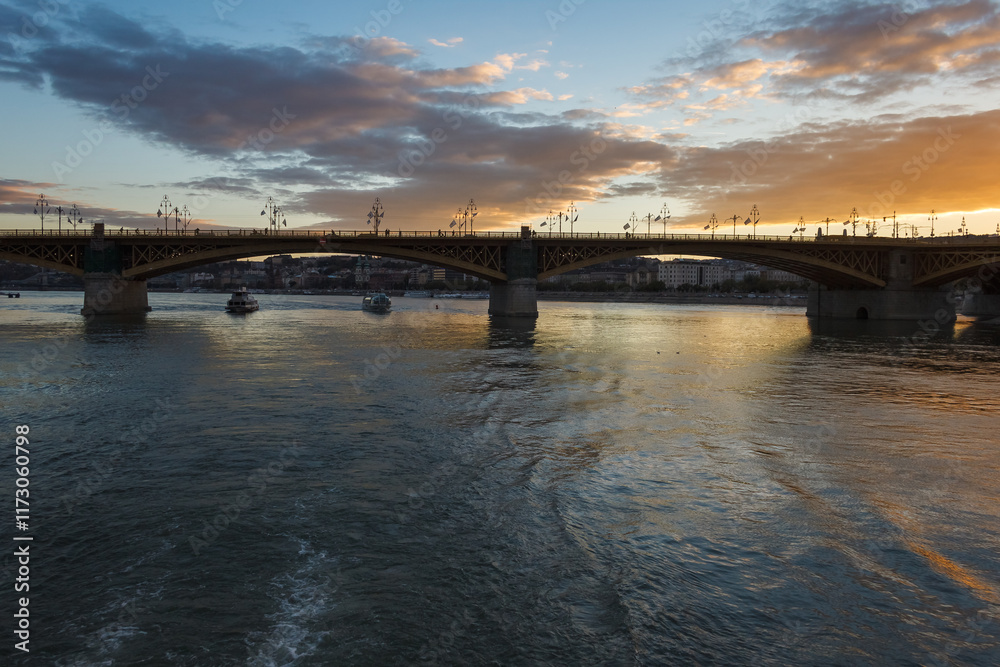 Bridge over the river against the backdrop of sunset. Clouds in the evening sky. Bridge over the river against the backdrop of sunset. Clouds in the evening sky.
