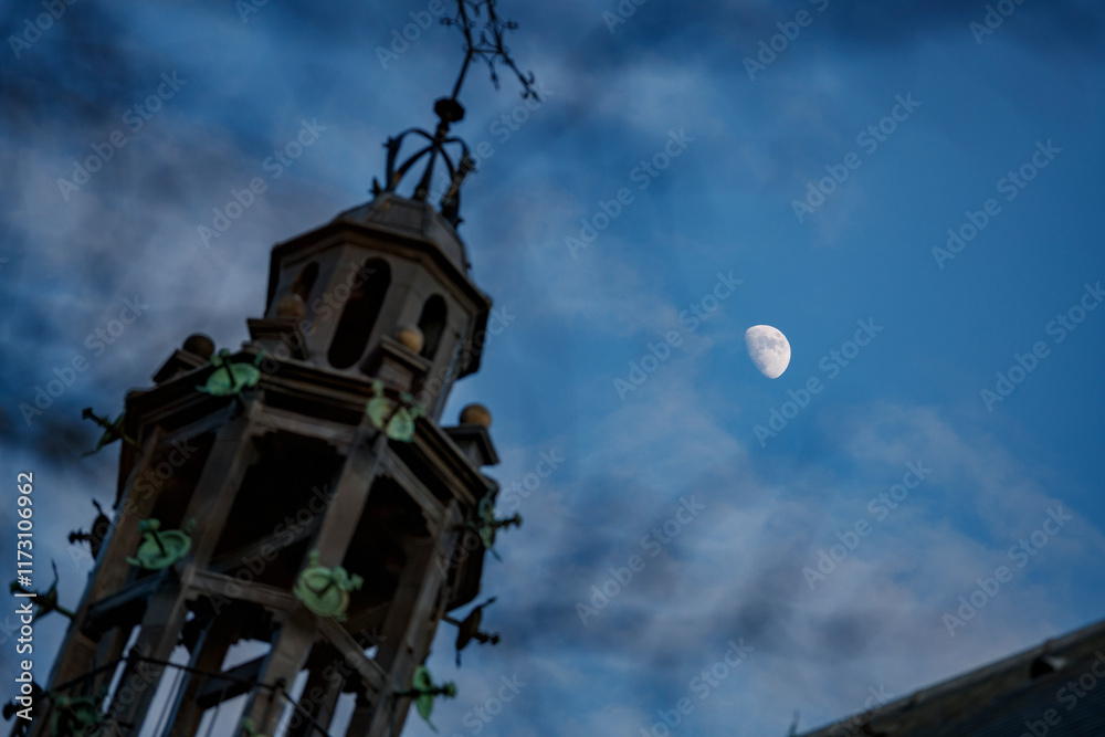 Towering structure reaching into the twilight sky with a crescent moon shining above in a serene evening atmosphere Towering structure reaching into the twilight sky with a crescent moon shining above in a serene evening atmosphere