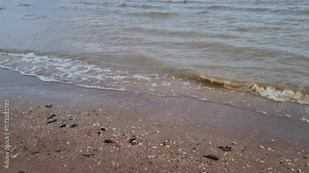Beautiful small waves on the beach in the afternoon when the weather is cloudy Beautiful small waves on the beach in the afternoon when the weather is cloudy