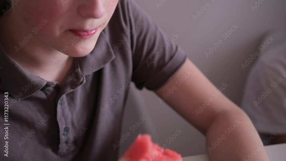 Boy eating watermelon focusing on sweet and juicy fruit. Male enjoying fresh slice of watermelon, biting into it with concentrated look. Guy savoring watermelon Boy eating watermelon focusing on sweet and juicy fruit. Male enjoying fresh slice of watermelon, biting into it with concentrated look. Guy savoring watermelon