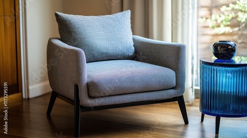 Modern grey armchair, blue side table, sunny room, interior design photo