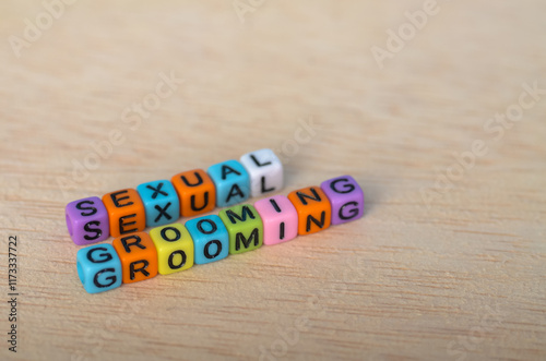Tableau sur toile Awareness Message 'SEXUAL GROOMING' in Bright Beads on Wooden Background