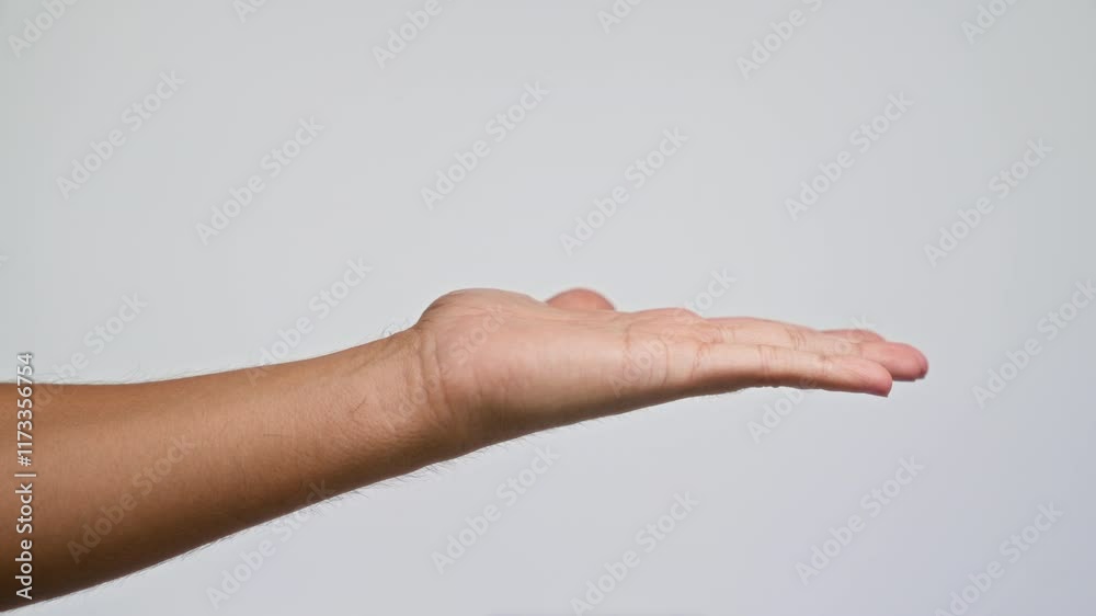 Man extends open hand against simple white background, emphasizing gesture and simplicity Man extends open hand against simple white background, emphasizing gesture and simplicity
