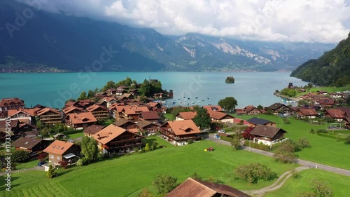 Iseltwald, Switzerland: Aerial drone footage of the famous Iseltwald village and countryside by lake Brienz in the Berner Oberland on a cloudy summer day. Shot with a forward motion