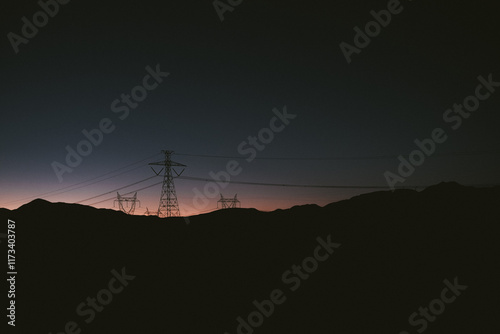 Silhouette of Electricity pylons in a desert landscape at sunset, Chile