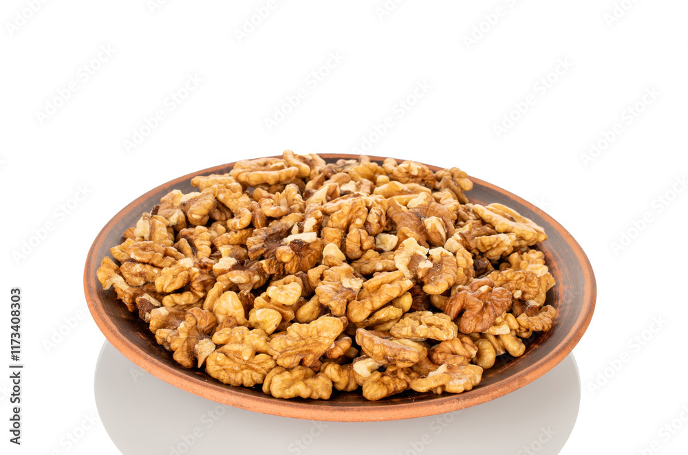Shelled walnuts on a clay plate, close-up, isolated on a white background. Shelled walnuts on a clay plate, close-up, isolated on a white background.