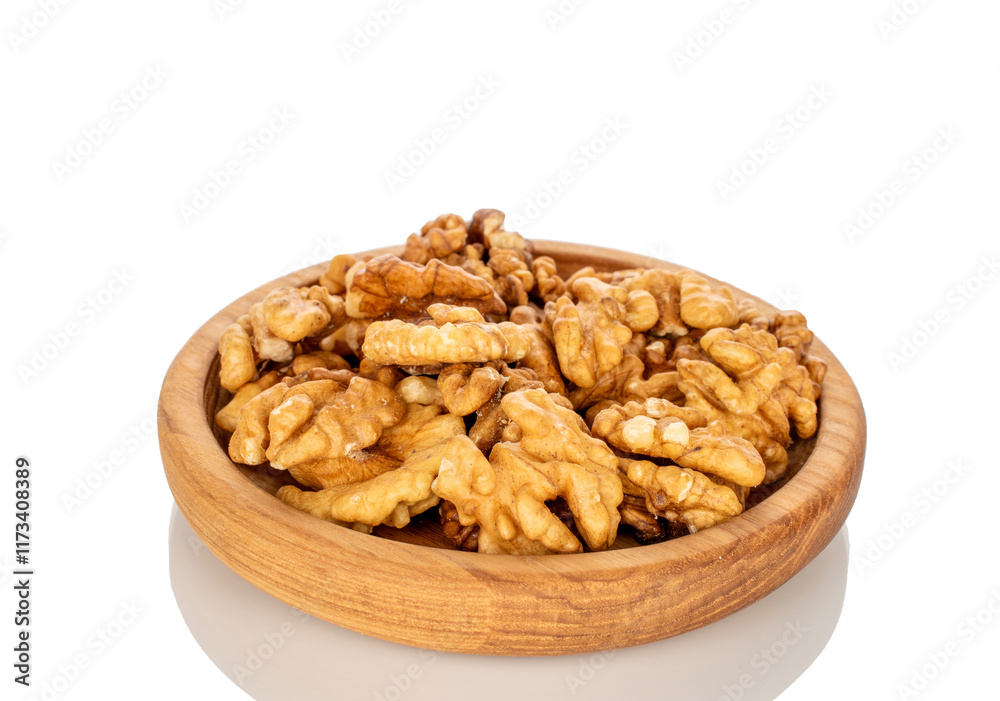 Shelled walnuts on a wooden plate, close-up, isolated on a white background. Shelled walnuts on a wooden plate, close-up, isolated on a white background.