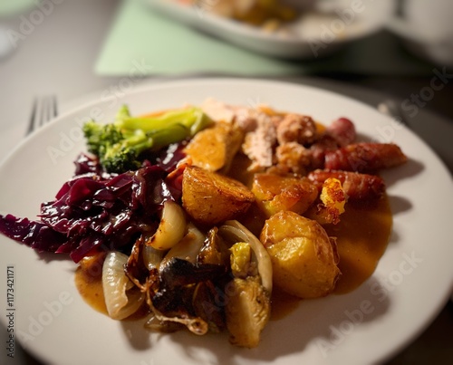 Close-up of a Christmas dinner with turkey, pigs in blankets, stuffing, roast potatoes, onion, red cabbage, brussels sprouts, broccoli and gravy