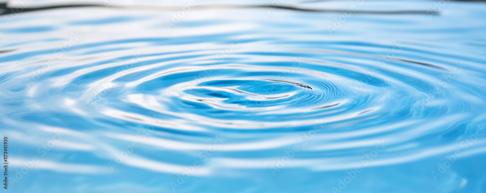 Close-up of delicate concentric waves propagating on a tranquil blue water surface, reflecting the sky and creating a mesmerizing, textured pattern Close-up of delicate concentric waves propagating on a tranquil blue water surface, reflecting the sky and creating a mesmerizing, textured pattern