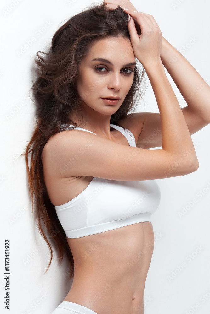 Young caucasian female with long hair and athletic figure wearing white sportswear Young caucasian female with long hair and athletic figure wearing white sportswear
