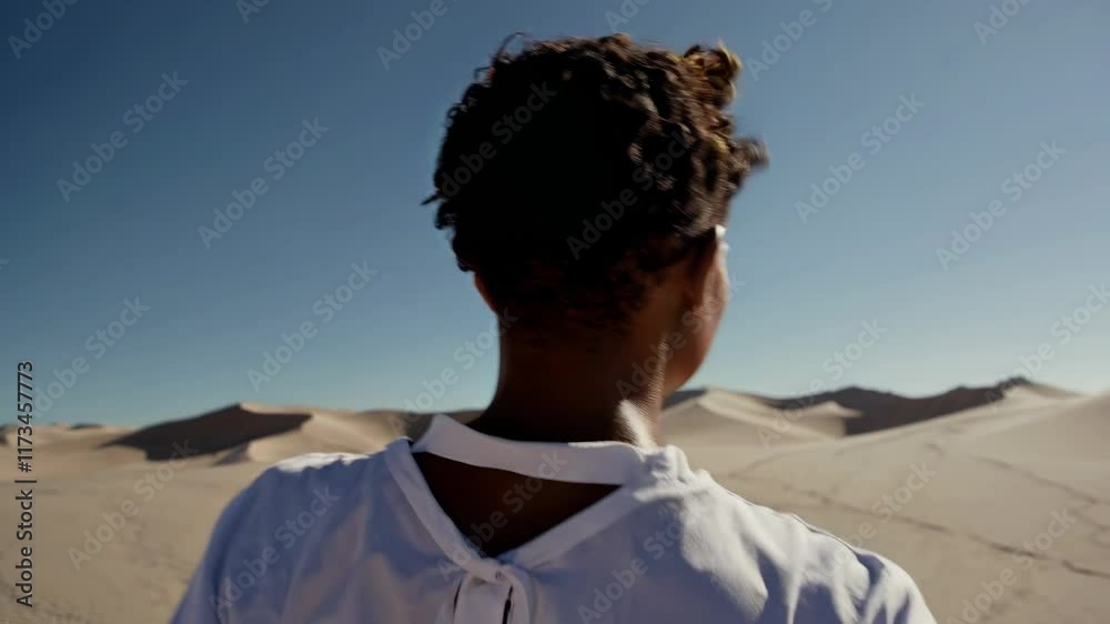 Woman Walking Alone Across Desert Dunes