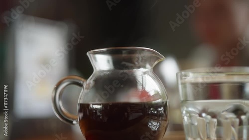 Pourover hot black coffee in a pot on the table in coffeeshop close-up. Beverage in restaurant, with the daylight in afternoon. V60 manual brew photo