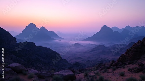  The prominent feature is the series of mountain peaks. They have sharp, defined shapes, suggesting rocky terrain. The varying shades of blue and purple create a sense of depth and distance. photo