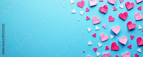 Pink and white heart-shaped confetti on a blue canvas with a large empty space for image composition, blue canvas, celebration photo