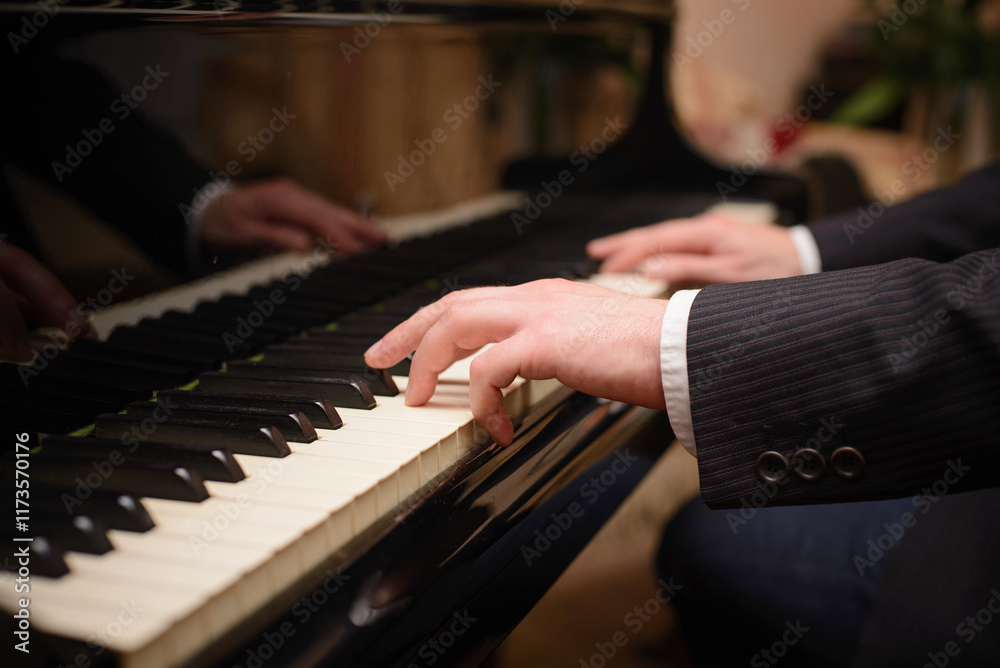 Fototapeta premium Close-up of a music performer's hand playing the piano