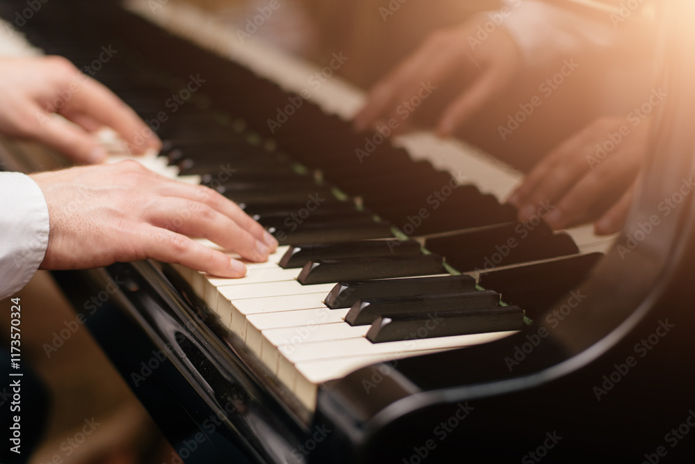 Fototapeta premium Close-up of a music performer's hand playing the piano