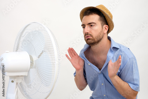 Flushed man feeling hot in front of a fan