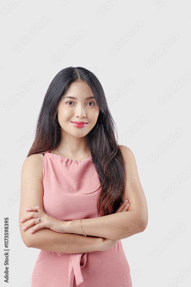 Confident young Asian woman wearing pink dress with arms crossed and happy expression. Confident young Asian woman wearing pink dress with arms crossed and happy expression.