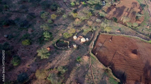 Aerial flyover of primitive village and farm with mud huts in the remote Borena Zone of Ethiopia photo