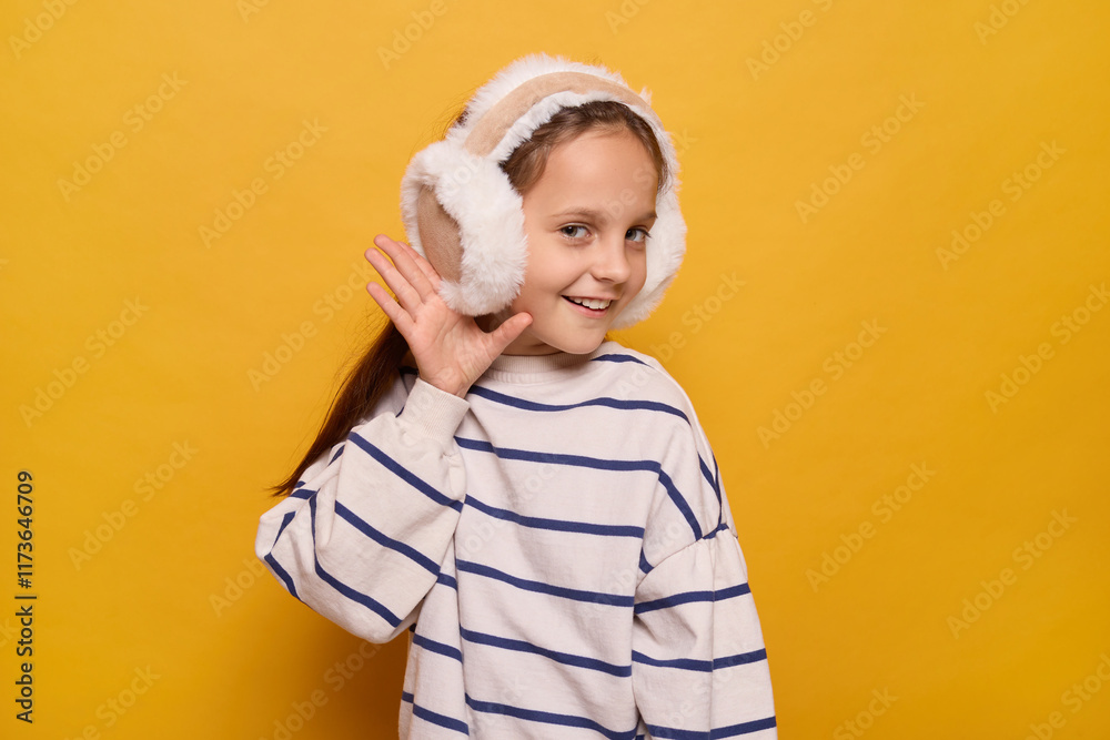 Ταπετσαρία A girl with long hair wears fluffy earmuffs while smiling and playfully raising her hand to her ear