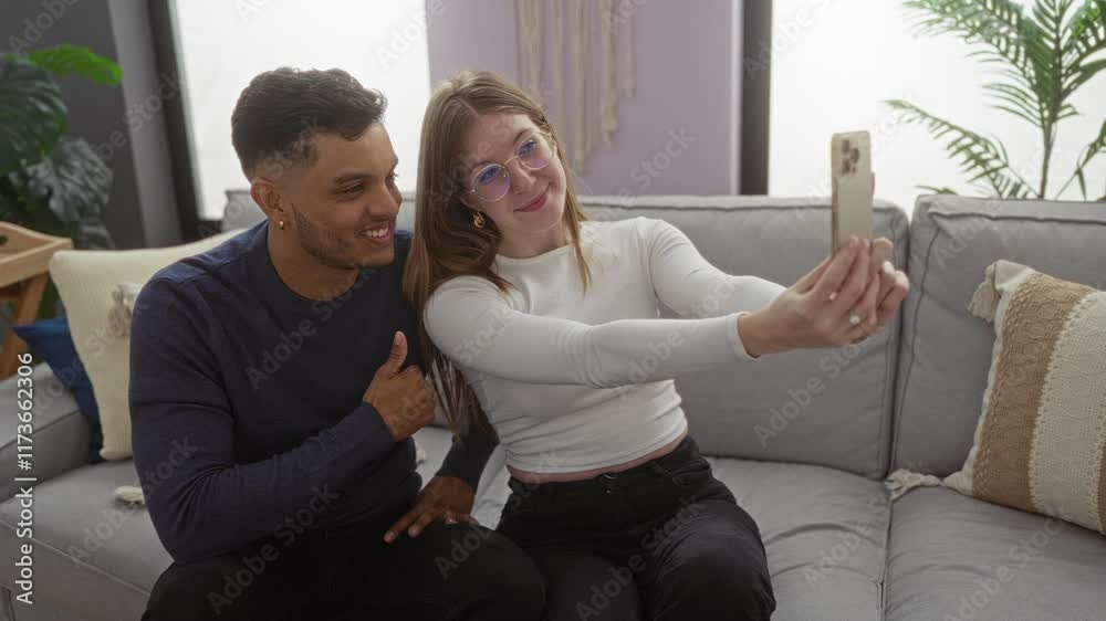 Couple taking selfie indoors on cozy sofa in modern apartment showcasing love and happiness Couple taking selfie indoors on cozy sofa in modern apartment showcasing love and happiness