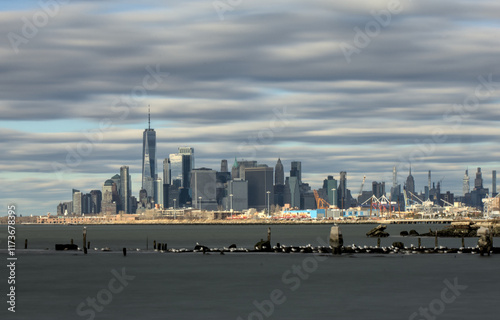 manhattan new york city skyline view from bush terminal park brookyn (downtown financial center skyscraper) dramatic sky clouds light sunset waterfront harbor river pier long exposure travel tourism photo