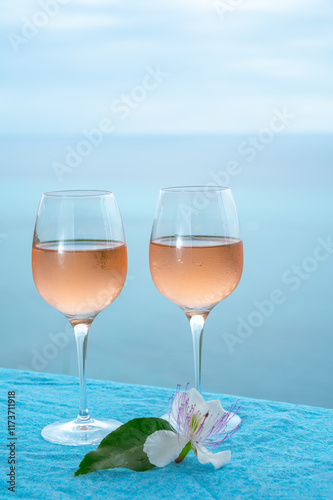 Summer time in Provence, two glasses of cold rose wine with blue sea view on background, French Riviera near Menton, south of France photo