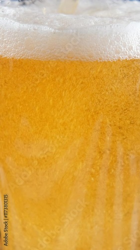 Vertical video. Pouring cold beer into a glass with crunchy snacks on a dark background