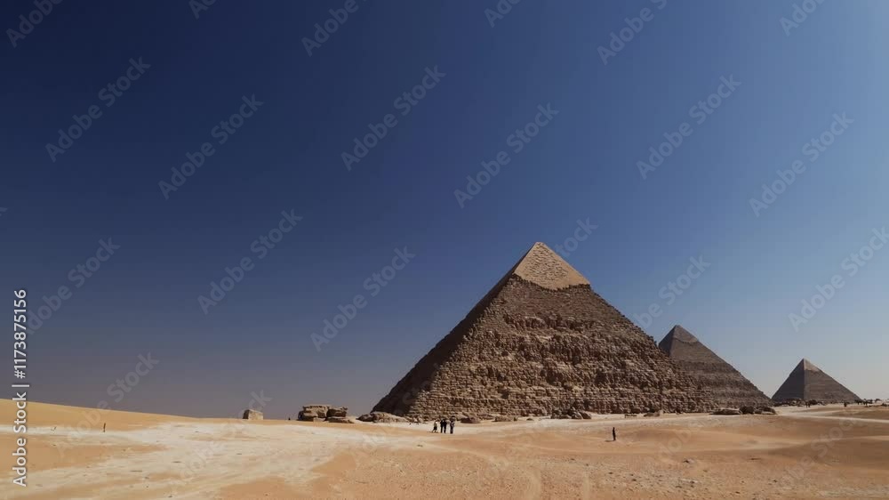Exploring the majestic pyramids at Giza under a clear blue sky during the warm afternoon sun Exploring the majestic pyramids at Giza under a clear blue sky during the warm afternoon sun