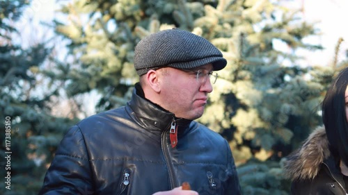 A man lights a cigar in a park.