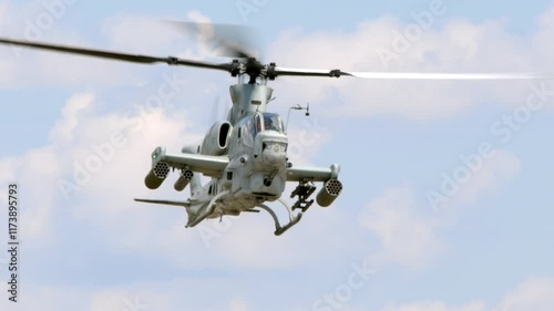 A United States Marines Bell AH-1 Cobra attack helicopter hovers and turns toward the camera in this slow motion shot.