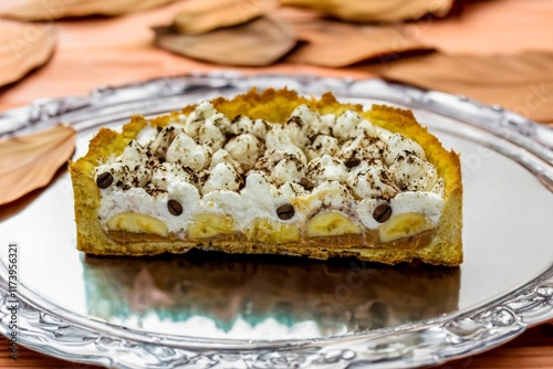 Authentic banoffee cake with banana and caramel sauce filling sprinkled with grated dark chocolate and coffee . English traditional pie photo