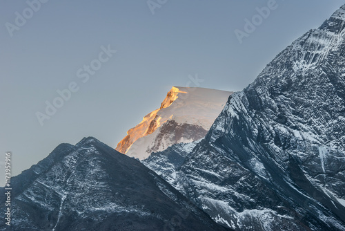 Snow covered mount illuminated by the first rays of the rising sun