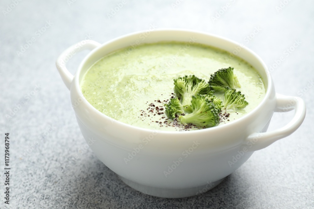 Delicious broccoli cream soup in bowl on light table, closeup Delicious broccoli cream soup in bowl on light table, closeup
