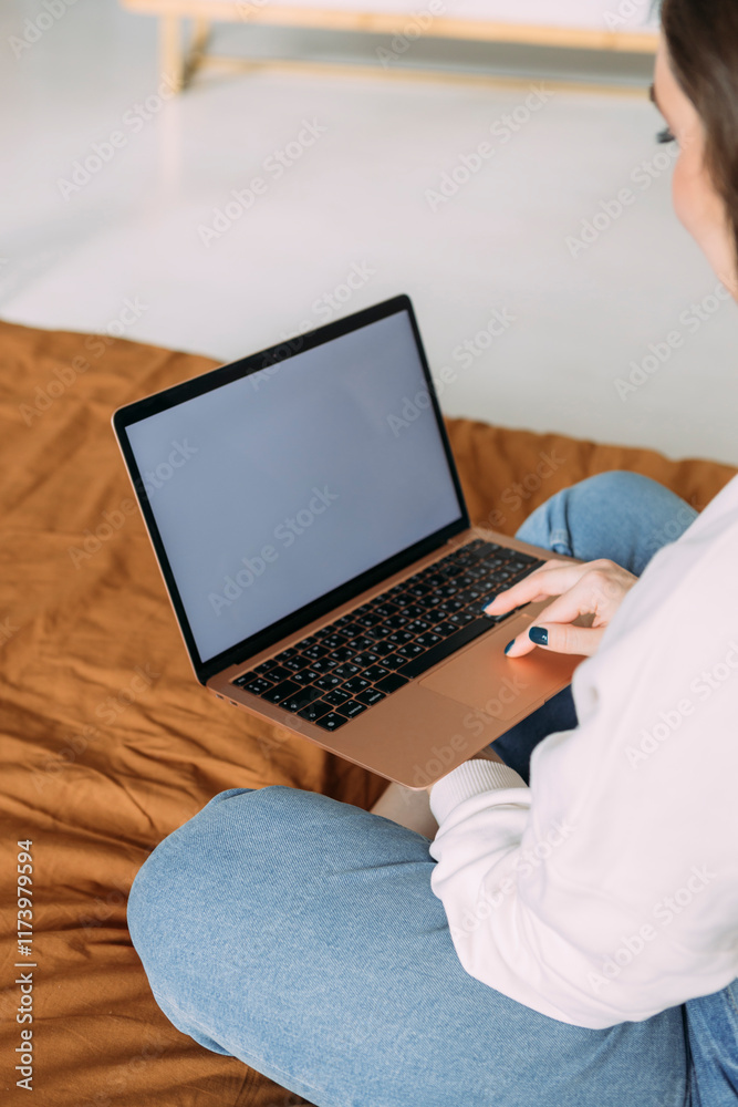 close-up photo of a girl working from home sitting on the bed holding a laptop on her lap close-up photo of a girl working from home sitting on the bed holding a laptop on her lap