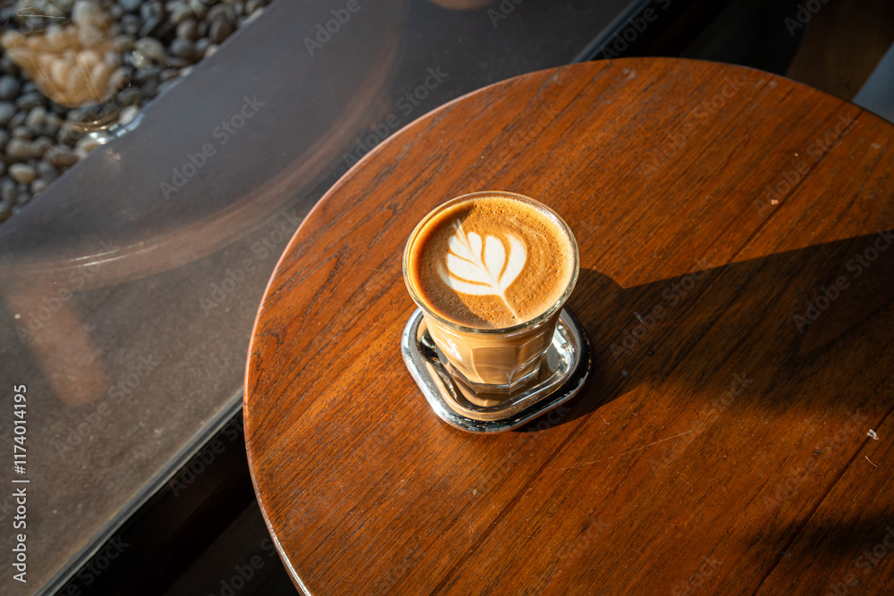 Hot coffee latte with latte art milk foam in cup mug on wood desk on top view. As breakfast In a coffee shop at the cafe,during business work concept,vintage style